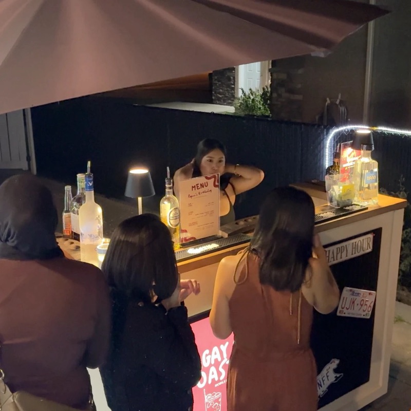 The Tagay & Toast bar cart serving guests under an umbrella at night
